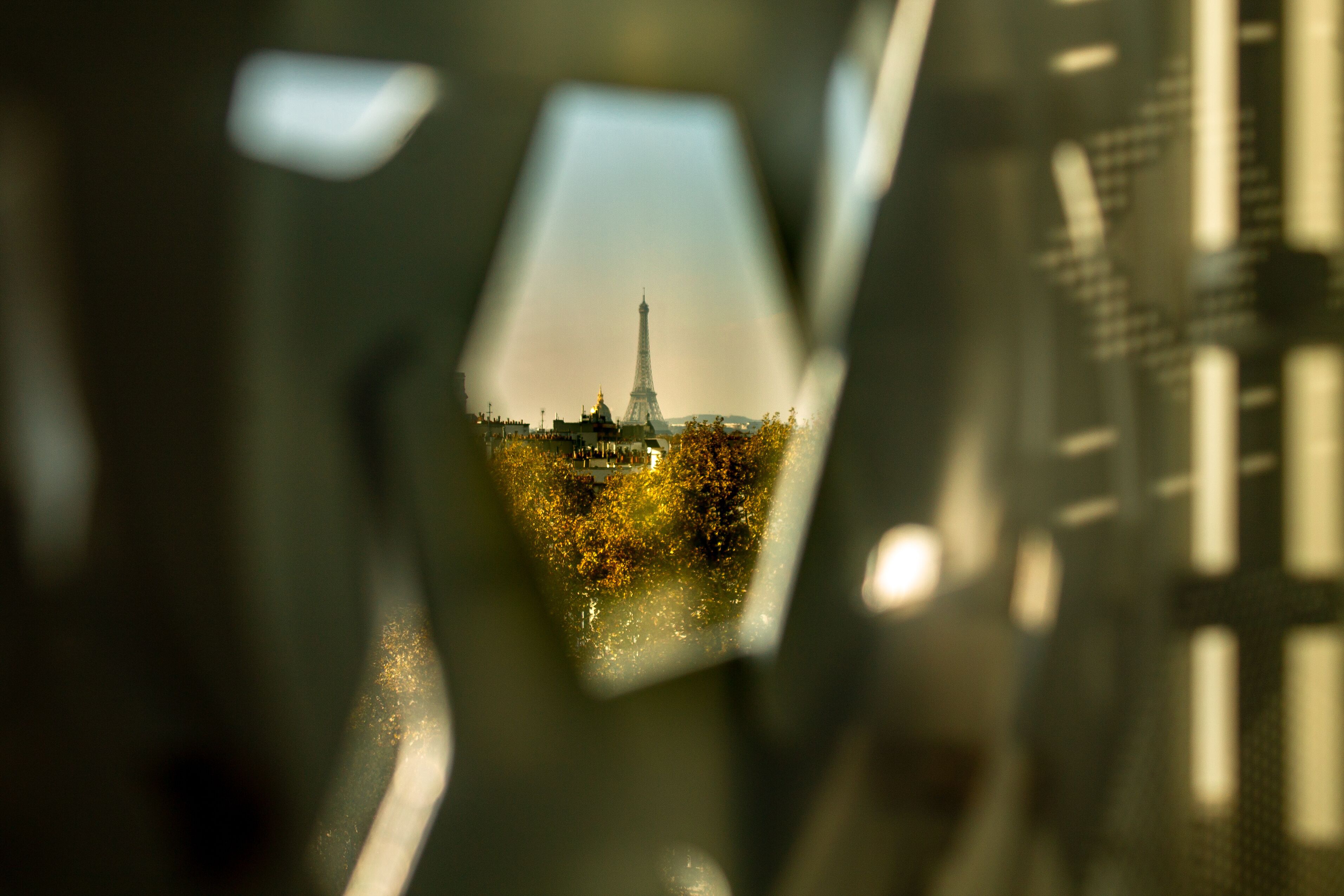 Amazing shot of The Eiffel Tower seen through the holes in the window of the Arab World Institute in Paris, France. Creative scene on a summer afternoon in this magic city in Europe.