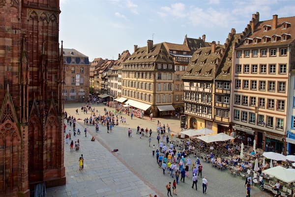 Une place animée, bordée de bâtiments historiques, dotée d’un pavé et agrémentée de cafés en plein air.