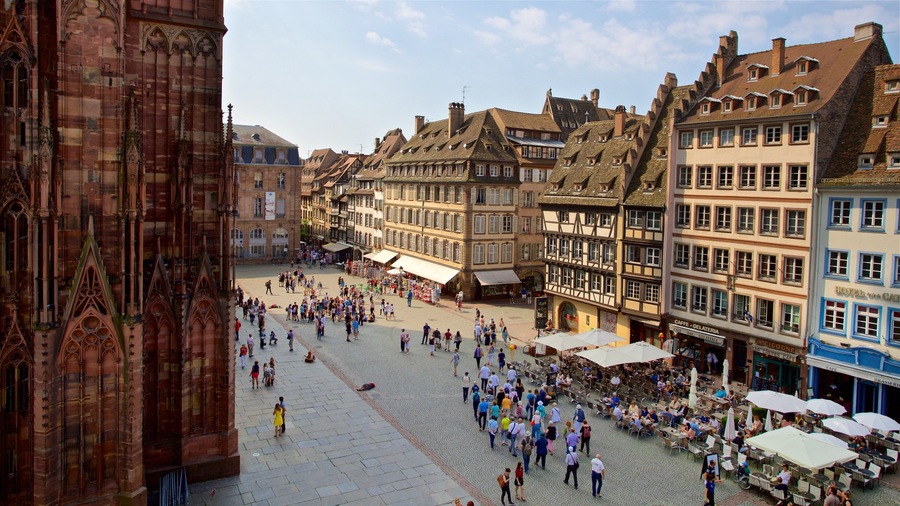 Una plaza animada con edificios históricos, adoquinado y cafés al aire libre.