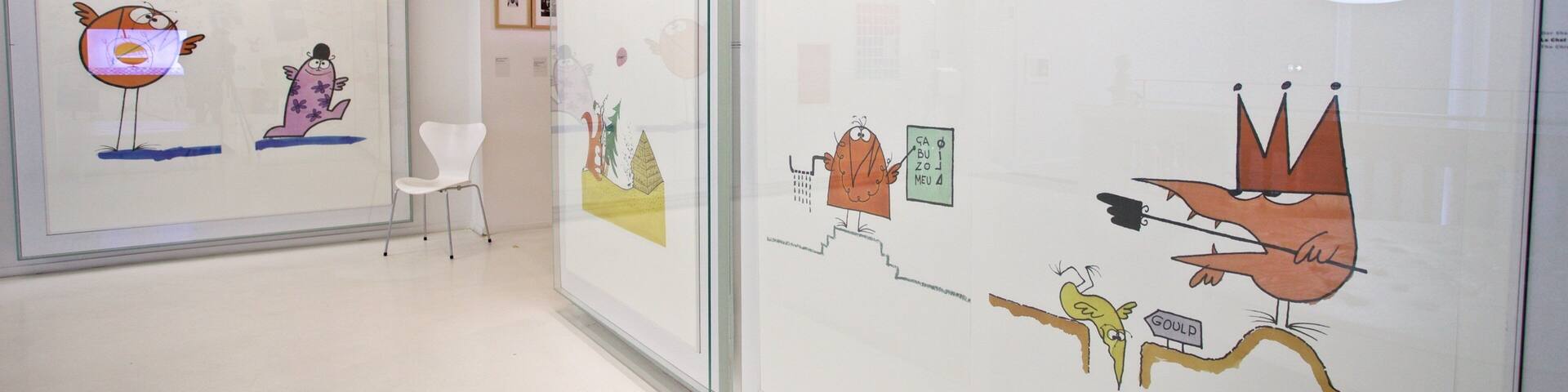 A gallery with glass walls displaying colorful cartoon characters and scenes.