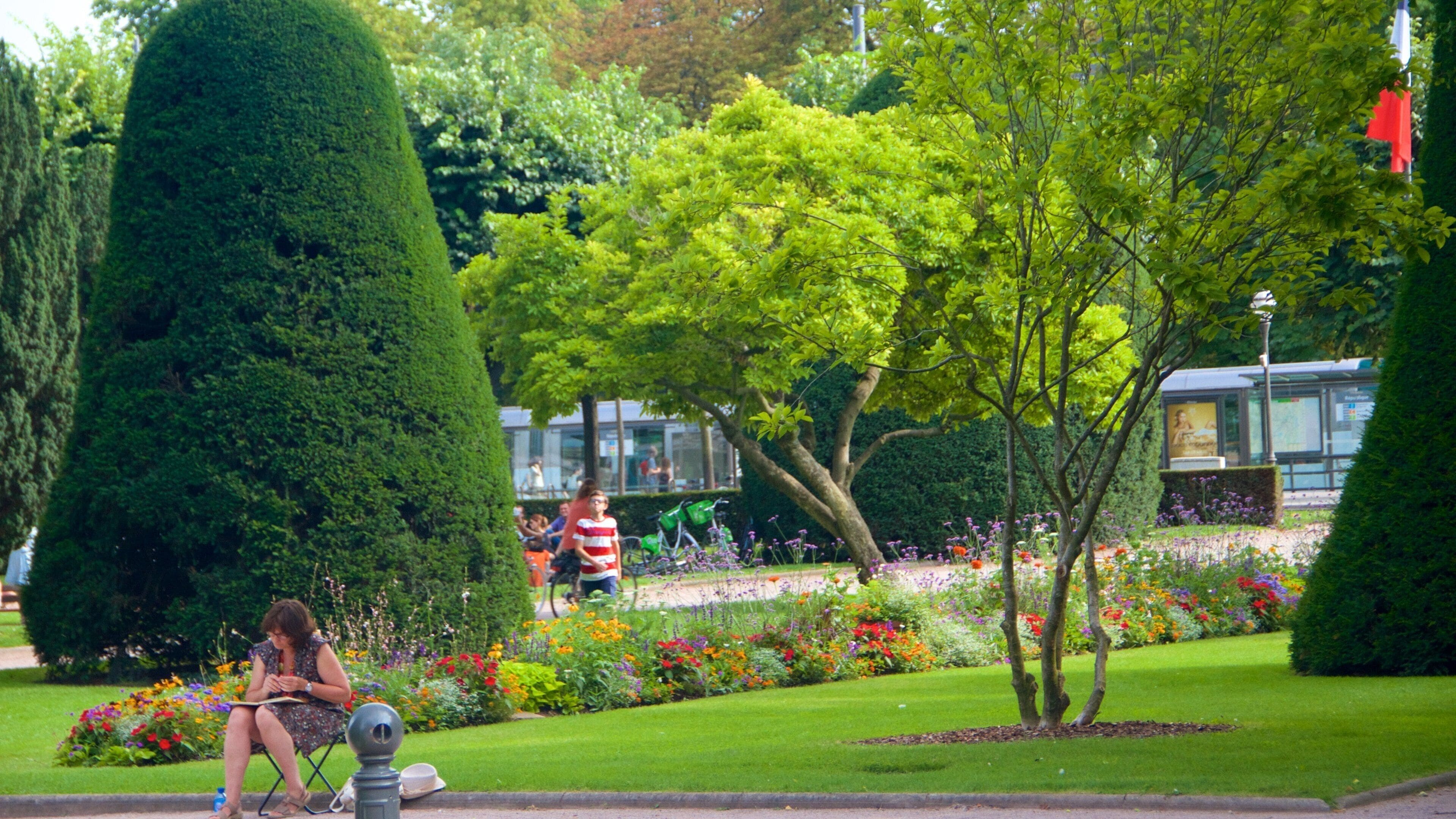 Plaza de la República que incluye flores y un parque y también una mujer