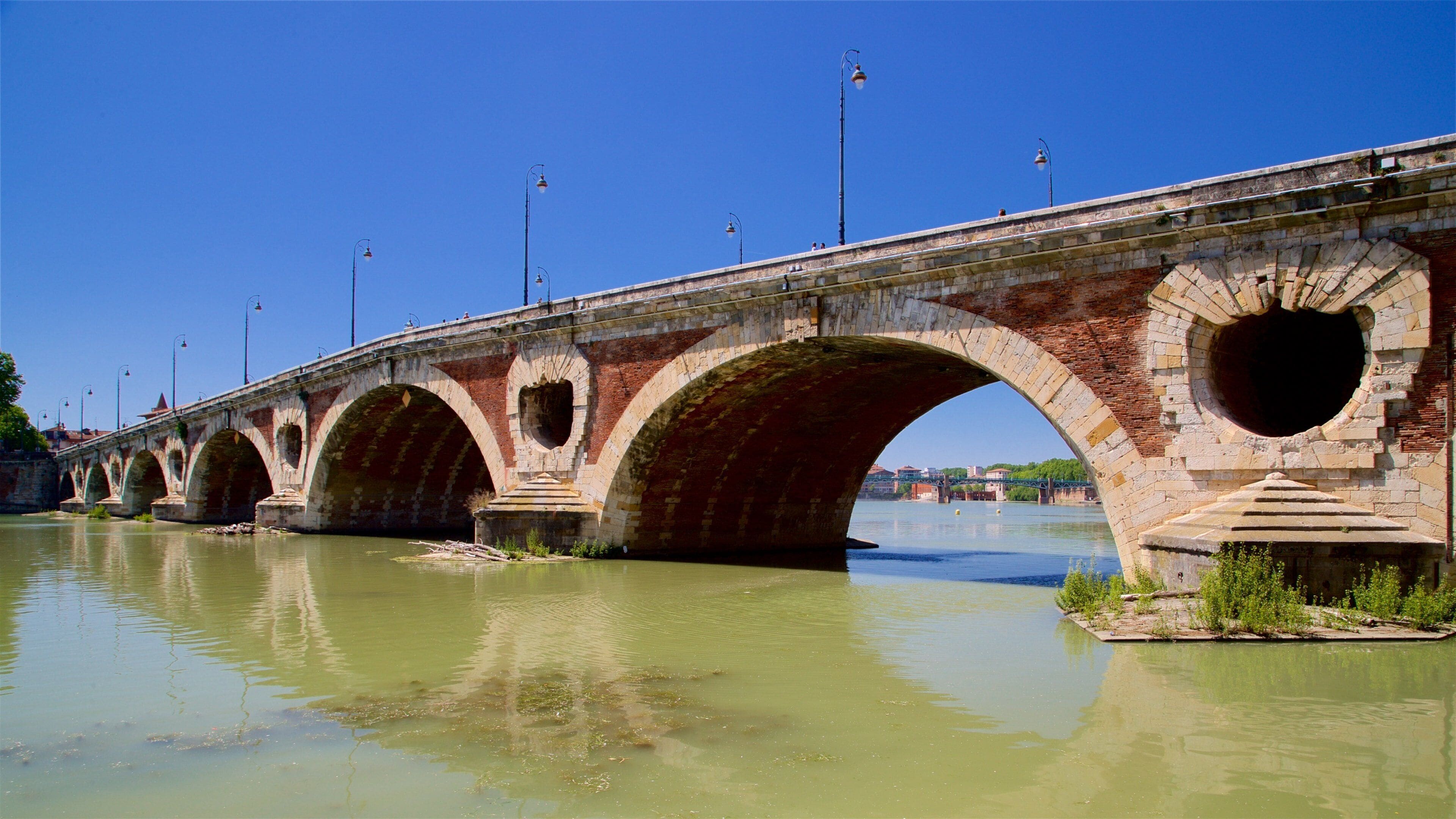 A stone bridge with multiple arches over a river.