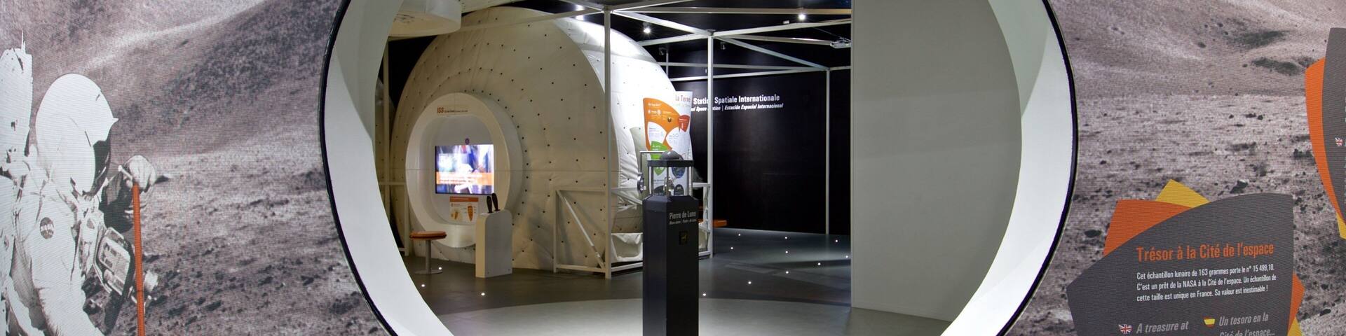 A space exhibit with a circular viewing area, a space shuttle model, and informational displays.