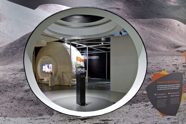 Une exposition sur l’espace comprenant une zone d’observation circulaire, une maquette de navette spatiale et des panneaux d’information.
