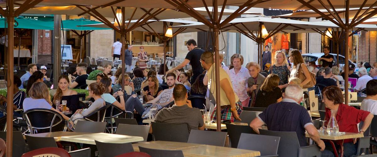 Saint George Place featuring outdoor eating as well as a large group of people