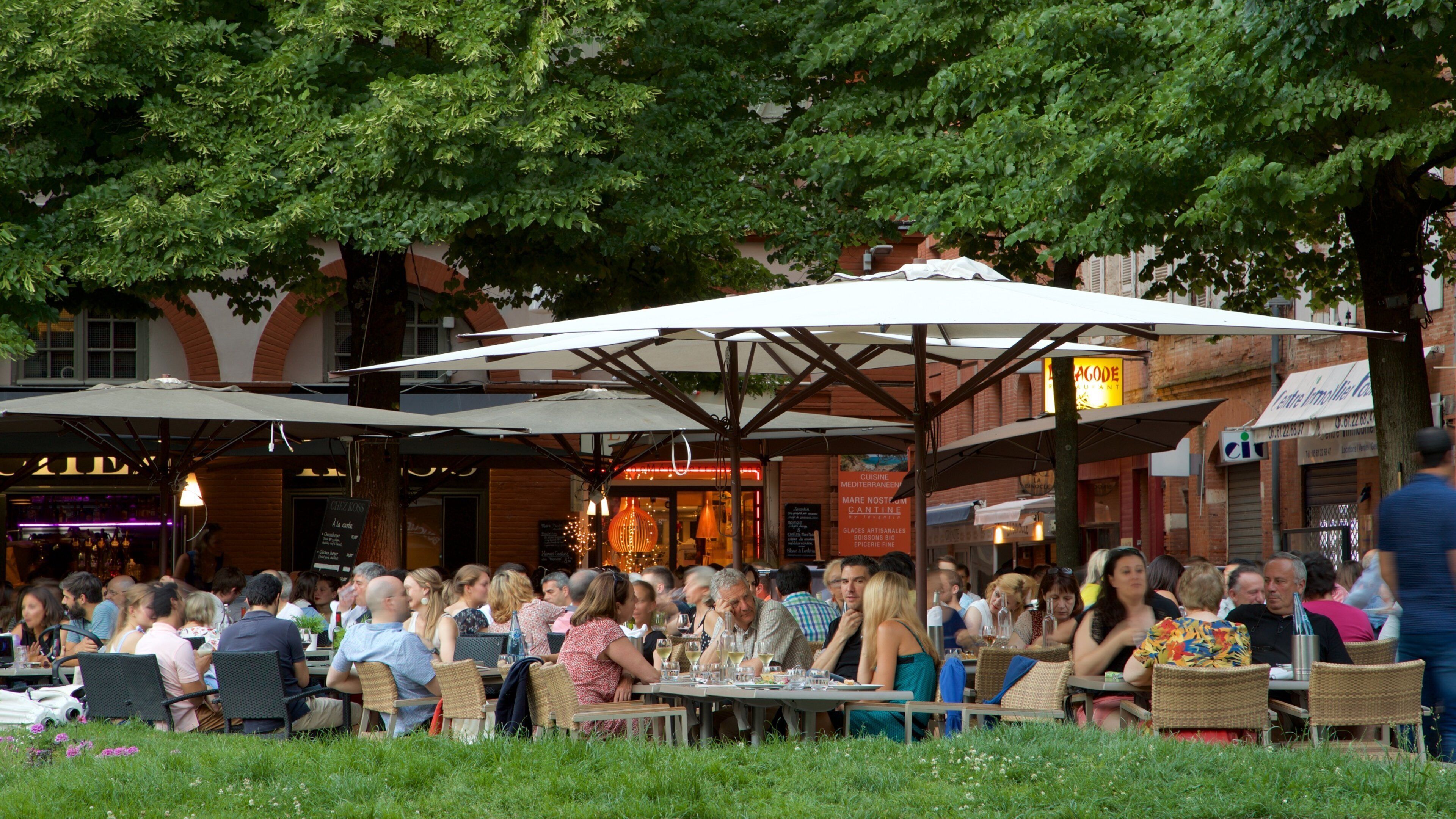 Espace Saint Georges som visar al fresco-restauranger såväl som en stor grupp av människor