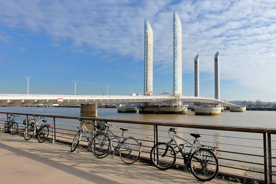 Un puente moderno con altos pilares y un río debajo.