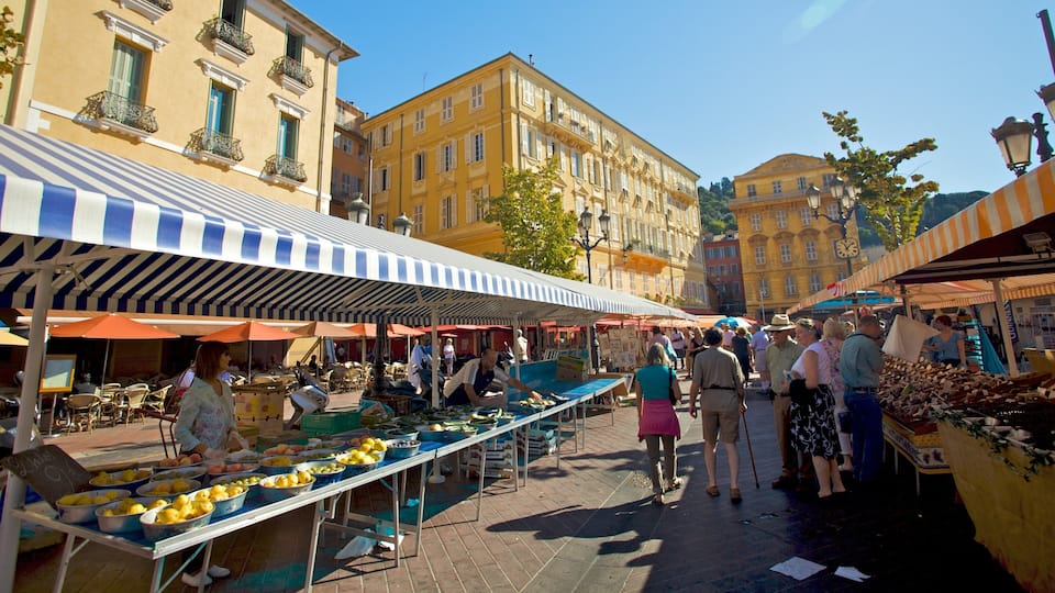 Ein lebhafter Markt im Freien, auf dem Verkäufer Obst und Gemüse unter bunten Markisen anbieten.