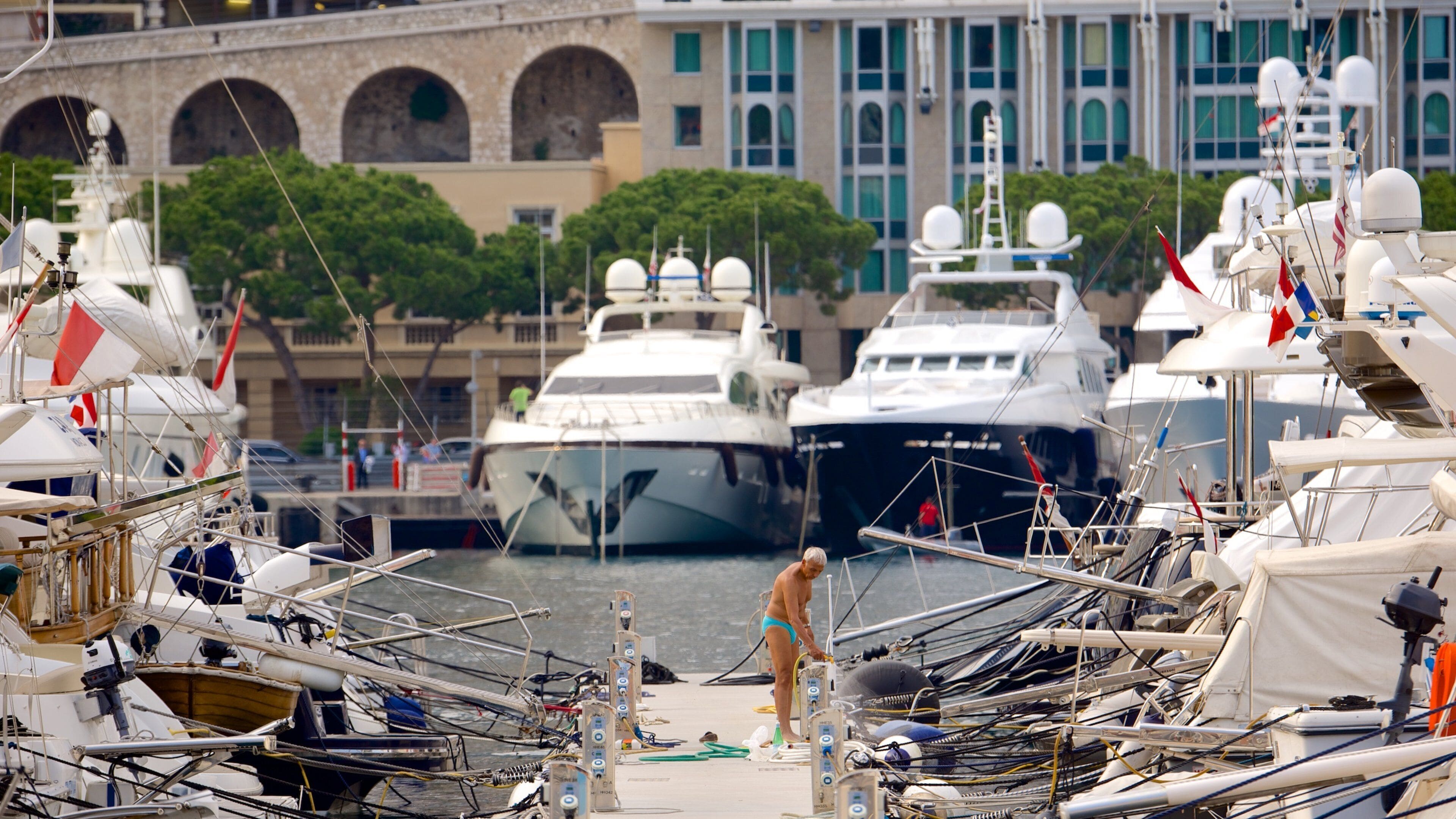 Monaco Harbour showing a bay or harbor as well as an individual male
