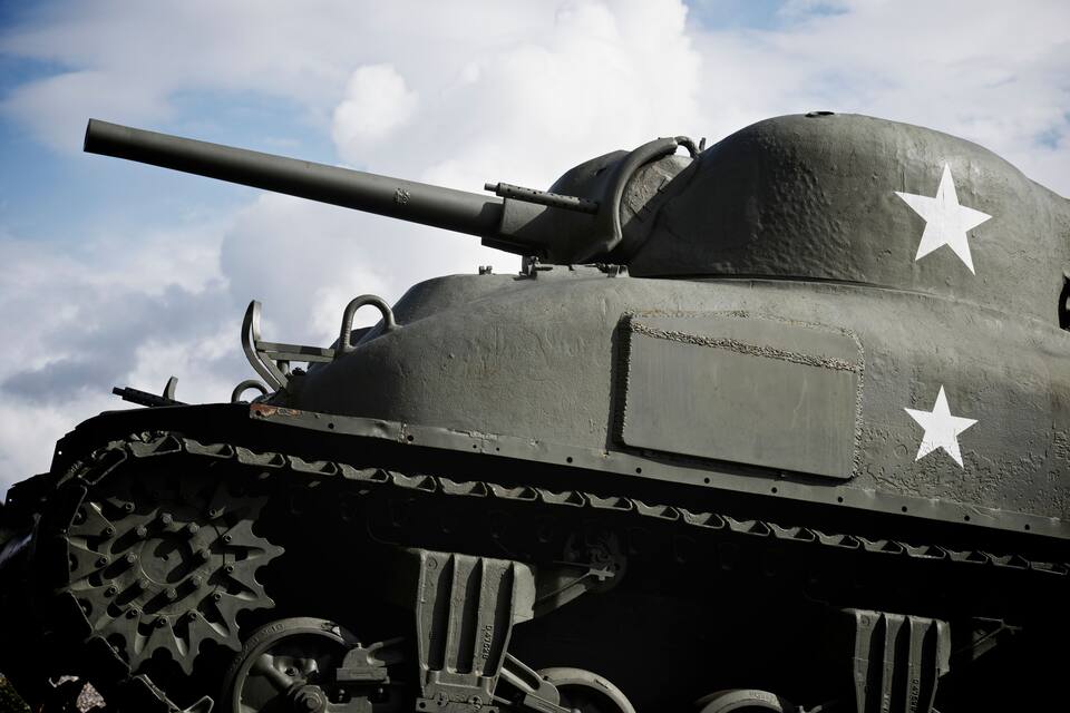 A military tank with a large gun barrel, tracks, and two white stars on its side.