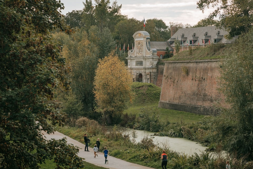 Un fort historique doté d’une tour centrale, entouré d’une végétation luxuriante et bordé par une rivière.