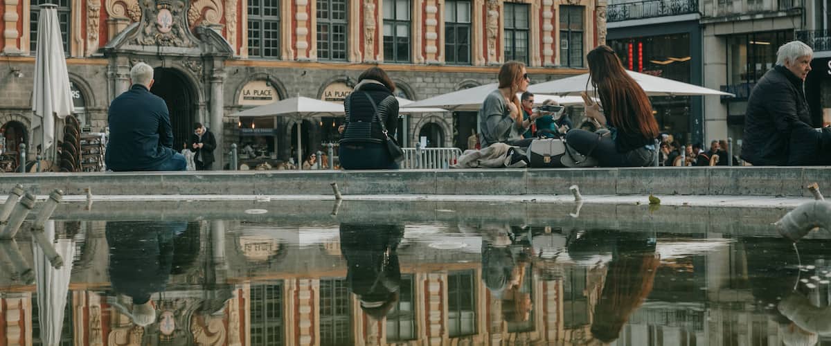 Lille Grand Square featuring a fountain and street scenes as well as a small group of people