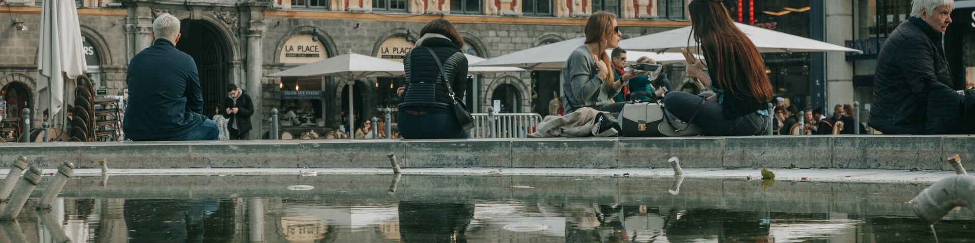 Lille Grand Square featuring a fountain and street scenes as well as a small group of people