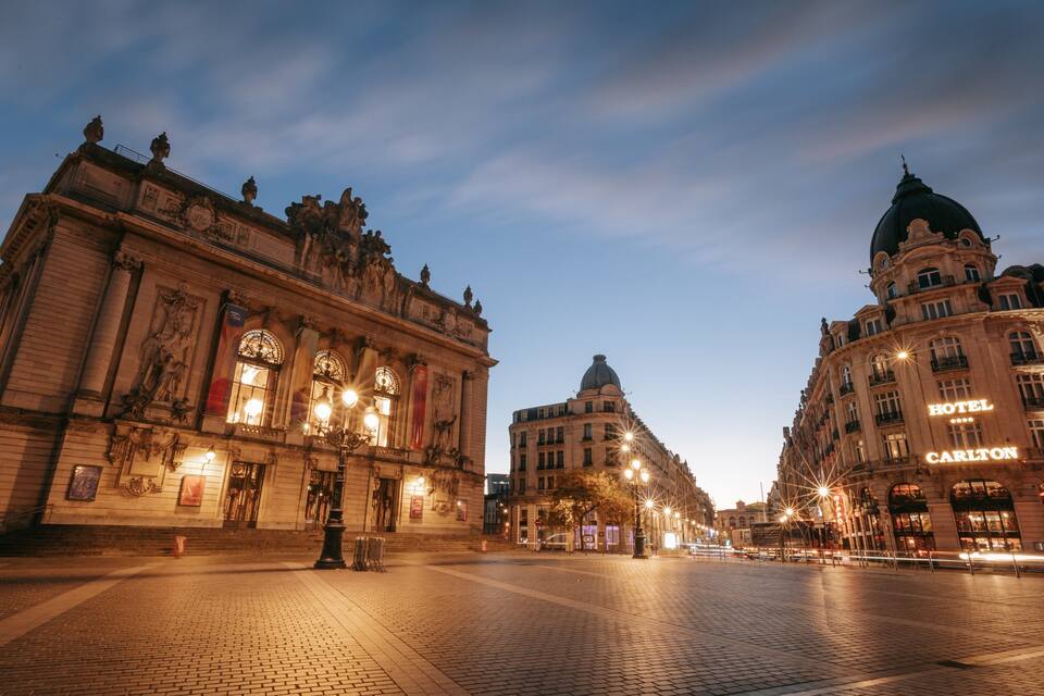 A historic square with ornate buildings, including a hotel named Carlton.