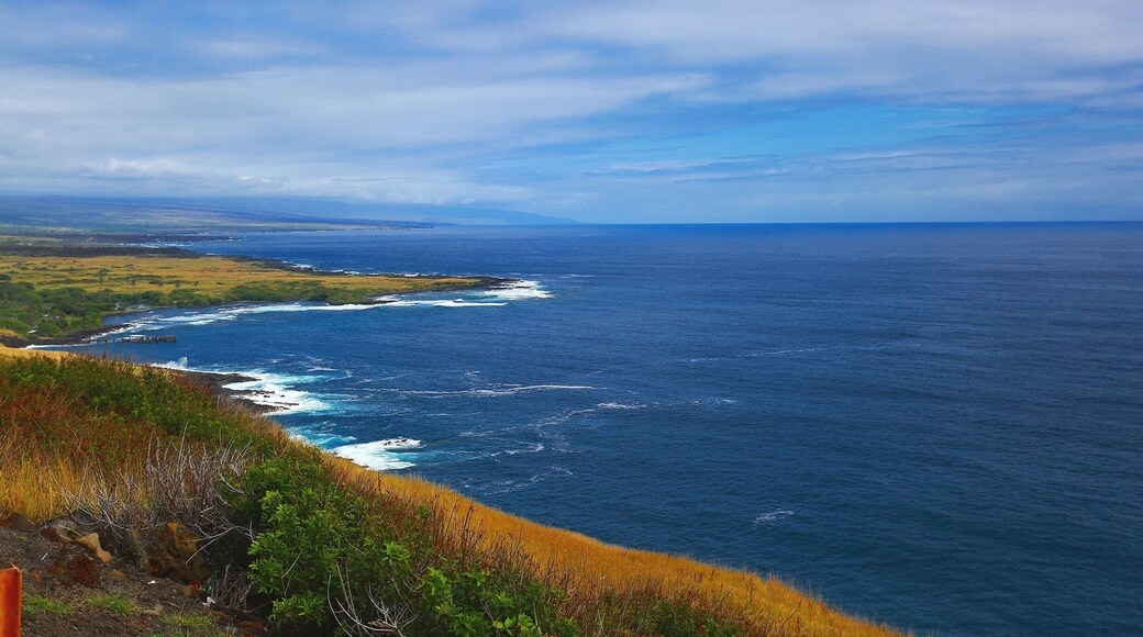 The beautiful Pacific Ocean just around the bend at South Point At Big Island, Hawaii. Blue skies, bluer waters and green green grass! Beautiful!