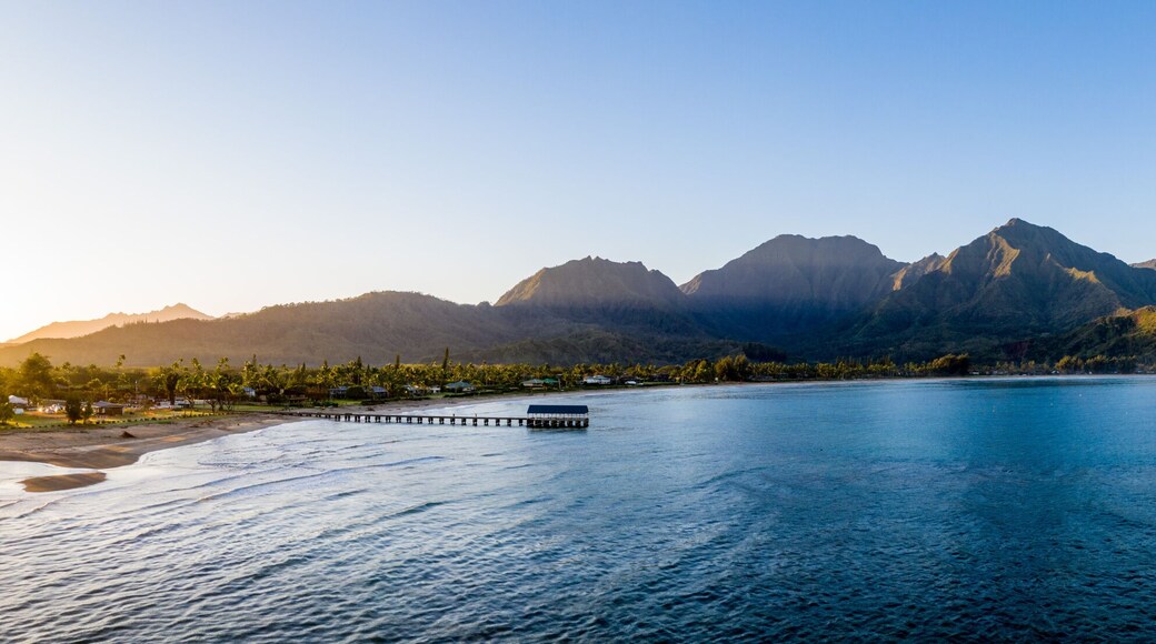 Aerial panoramic image at sunrise off the coast over Hanalei Bay and pier on Hawaiian island of Kauai