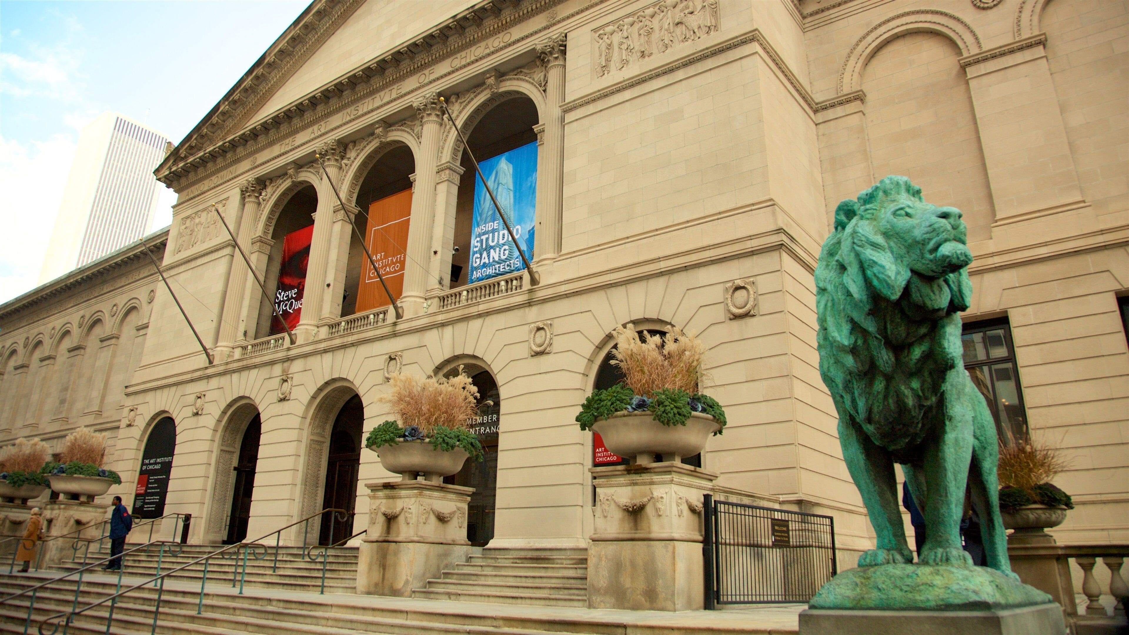 Das Gebäude des Art Institute of Chicago mit klassischer Architektur, einer Löwenstatue und Bannern, die Veranstaltungen bewerben.