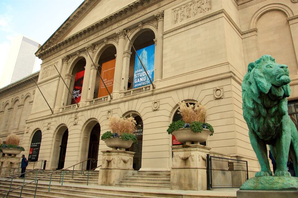 Das Gebäude des Art Institute of Chicago mit klassischer Architektur, einer Löwenstatue und Bannern, die Veranstaltungen bewerben.