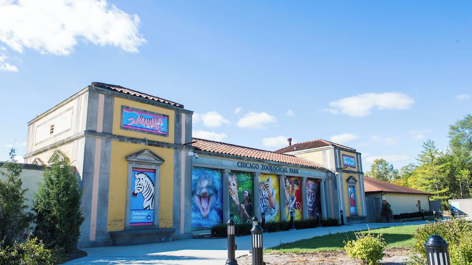 The Chicago Zoological Park building with colorful murals of animals and a clear blue sky.