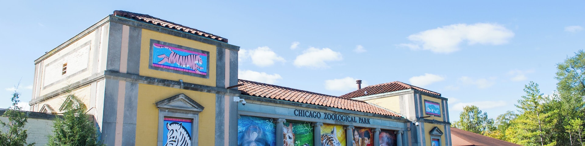 The Chicago Zoological Park building with colorful murals of animals and a clear blue sky.