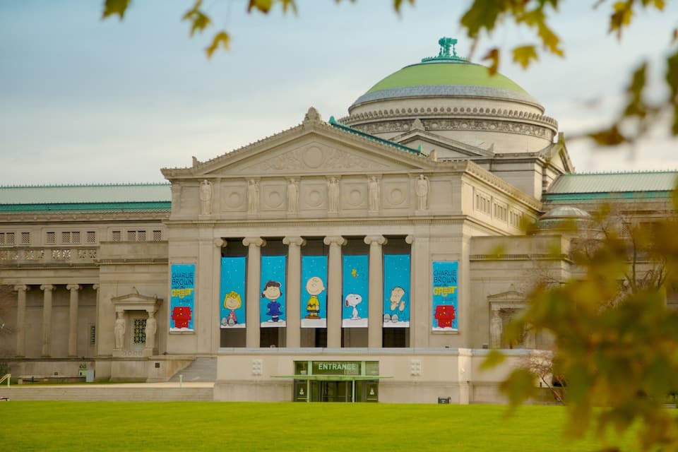 A classical building with a dome and columns, featuring Charlie Brown exhibit banners.