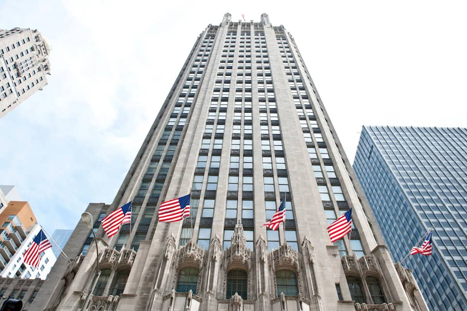 A tall building with multiple American flags.