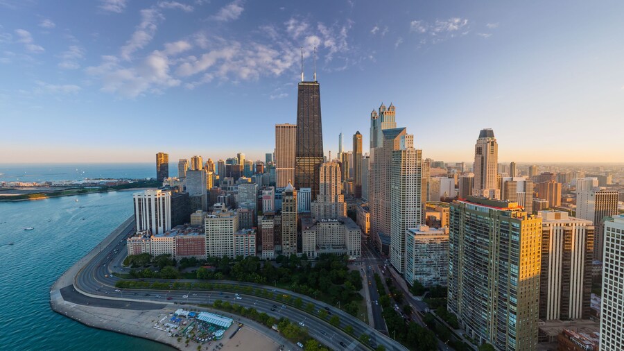 Aerial view of the iconic John Hancock Center and shimmering skyscrapers meeting the tranquil blue of Lake Michigan's shoreline, Chicago, Illinois, United States.