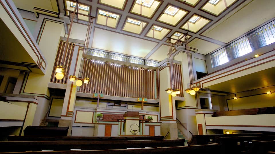A church interior with a high ceiling, stained glass windows, and wooden pews.