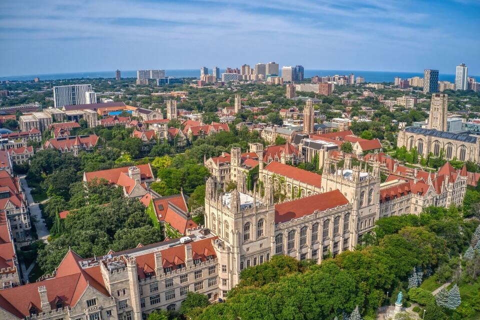 A cityscape with historic buildings, a prominent church, and a view of the ocean.