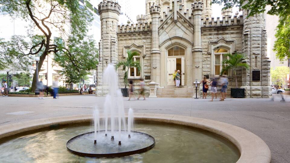 A historic building with a fountain in the foreground.