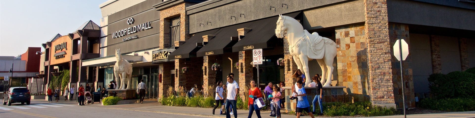 A street with a building labeled "Woodfield Mall" and a horse statue.