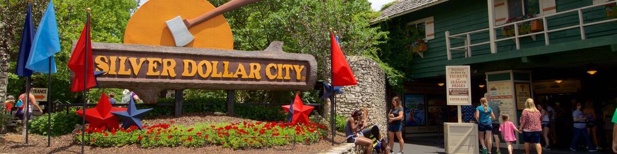 Silver Dollar City featuring flowers and signage as well as a small group of people