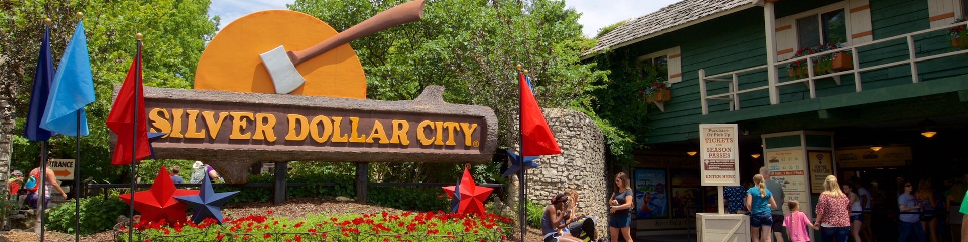 Parque Silver Dollar City mostrando flores e sinalização assim como um pequeno grupo de pessoas