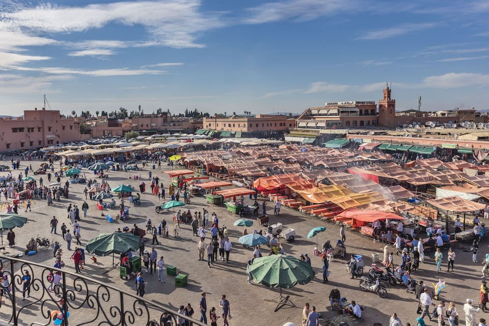 A bustling outdoor market with numerous stalls and people.