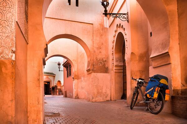 mountain bike standing near a red wall in the Muslim city of Marrakech in the street with beautiful arches and walls, ornamented tiles.; Shutterstock ID 184584899