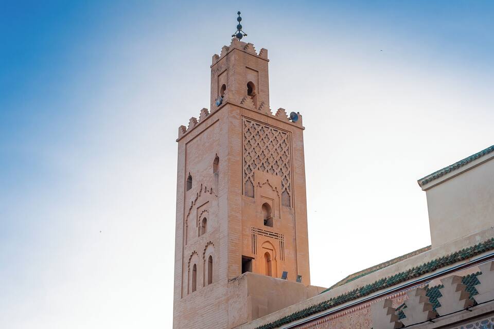 A tall tower with intricate carvings and a pointed roof.
