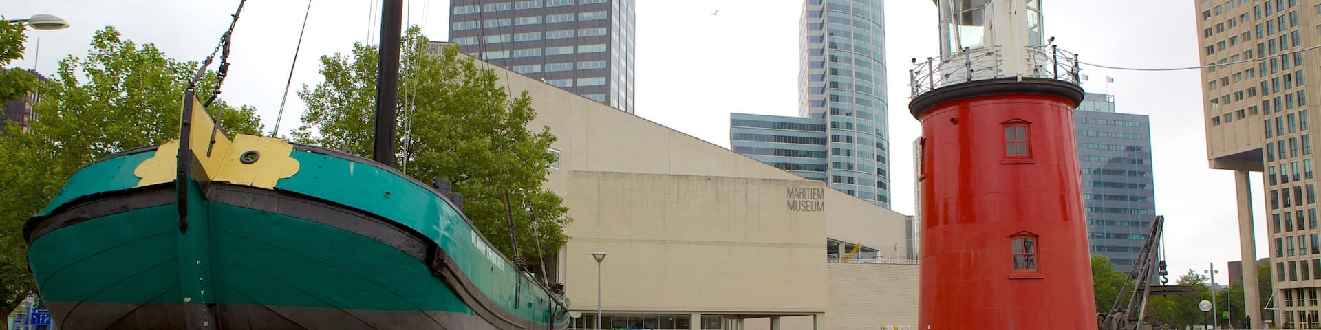 A large green and yellow boat, a red lighthouse, and modern buildings including the Maritimemuseum.