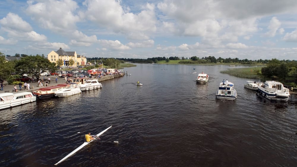 A river with boats, a dock, and a building in the background.