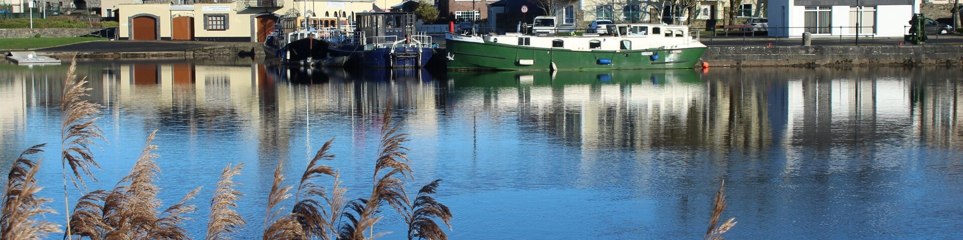 Un río tranquilo con barcos, una iglesia y casas a lo largo de sus orillas.