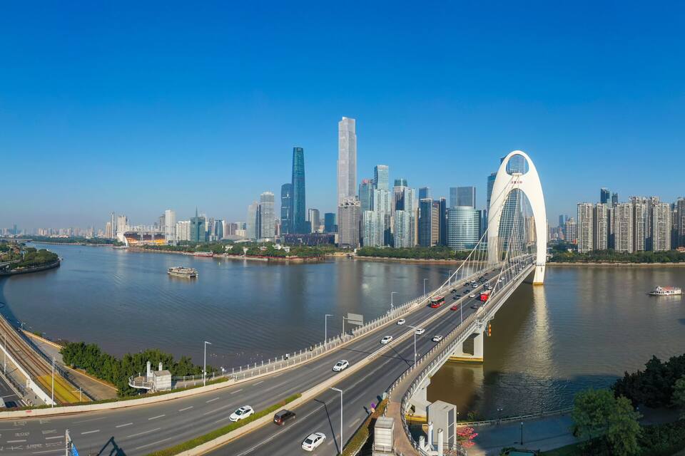 A city skyline with a prominent tower, a bridge, and a river.