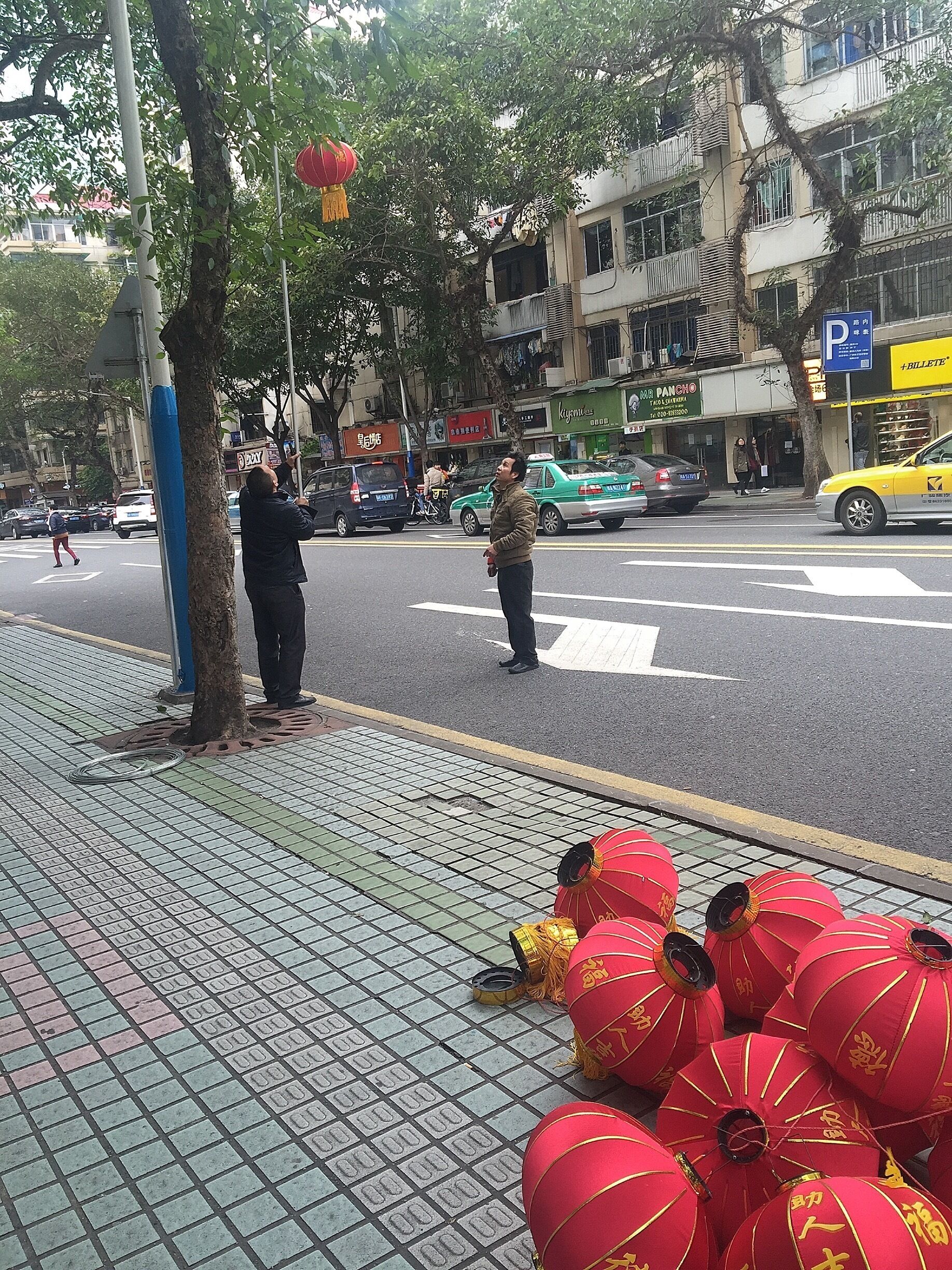 Workers are hanging on traditional lantern along the street to celebrate incoming Lunar New Year！