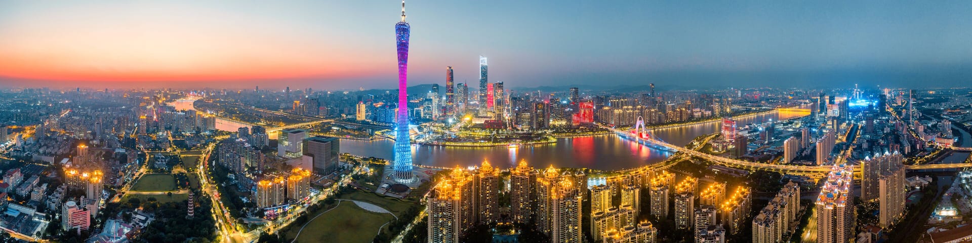 A cityscape with a prominent tower, a river, and surrounding high-rise buildings.