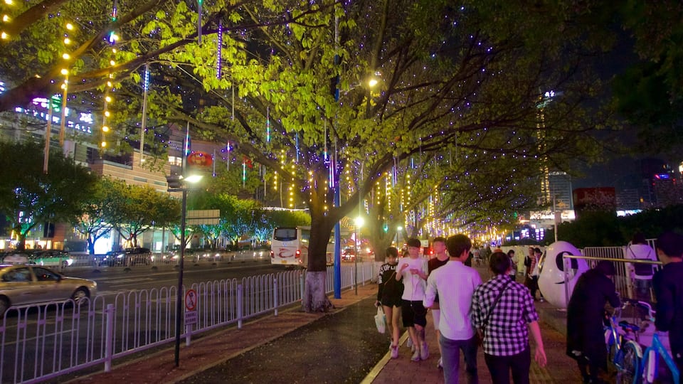 Tianhe showing a city and night scenes as well as a small group of people
