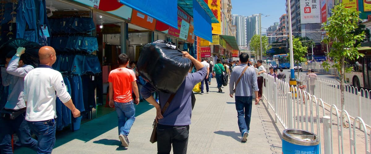 A busy urban street with pedestrians, storefronts, and high-rise buildings.