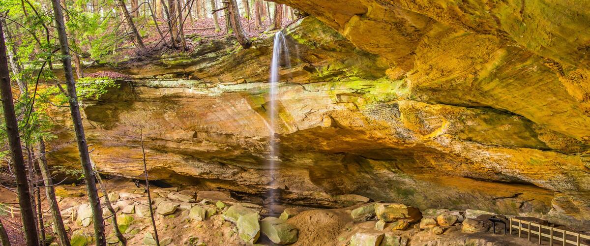 A waterfall cascading down a rocky cliff surrounded by trees.