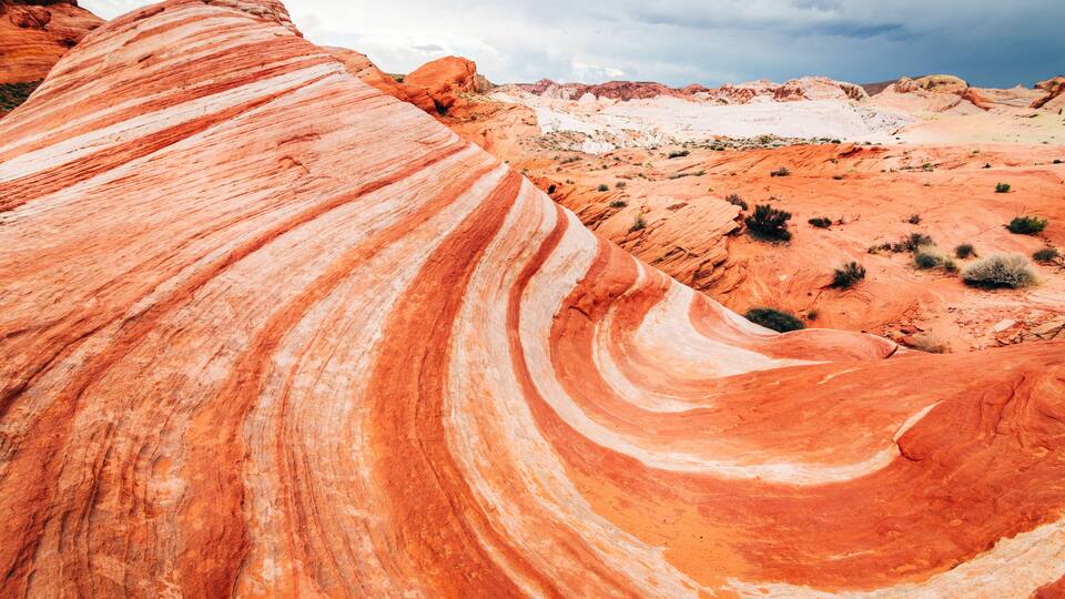 A red rock formation with a curved overhang.