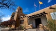 A building with a distinctive architectural style, featuring a tower and a covered entrance.