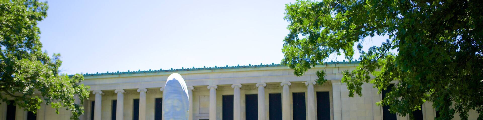 The Albright Knox Art Gallery with a large sculpture in front and a classical building in the background.