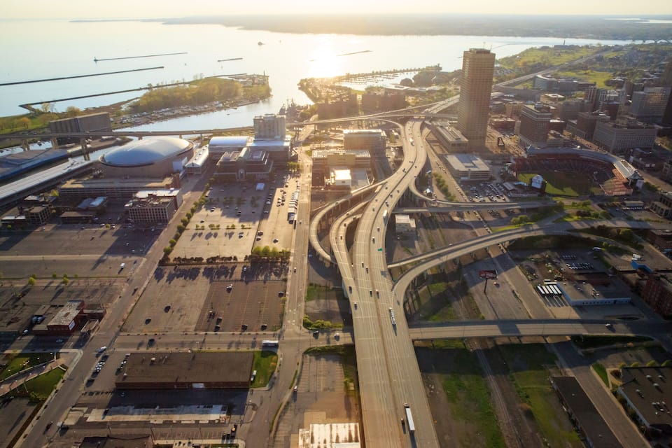 An aerial view of a city with a river, bridges, highways, and a stadium.