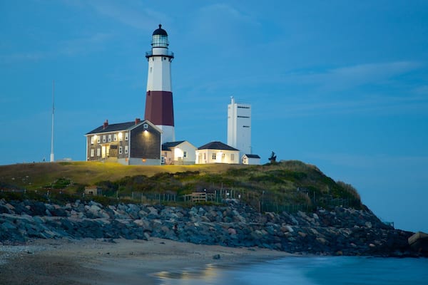 Montauk Point Lighthouse featuring rocky coastline, a lighthouse and a sandy beach